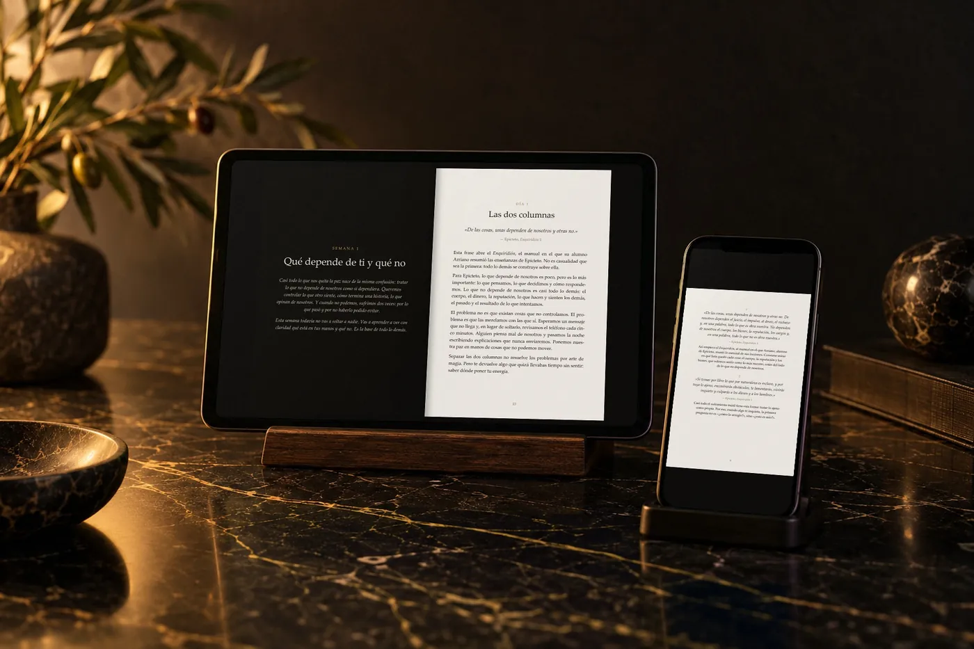 El libro abierto en una tableta y en un celular, sobre una mesa de mármol